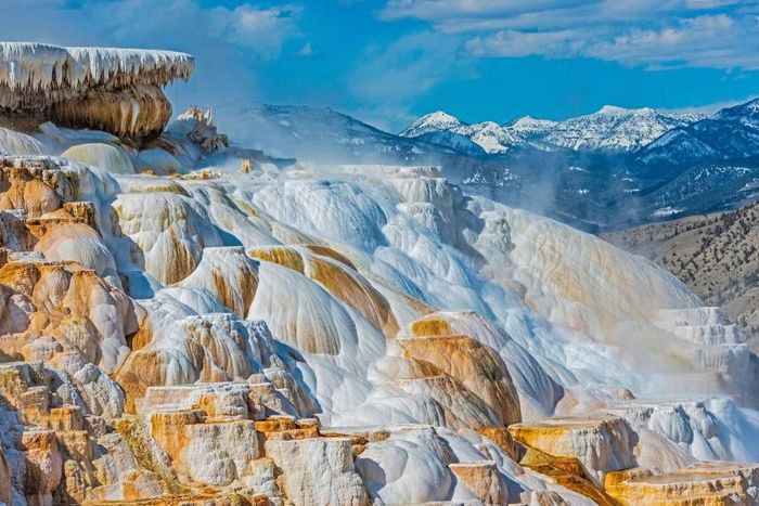 Những tầng travertine sáng màu và các dải khoáng chất vàng cam ở suối nước nóng Mammoth. Ảnh: Wikimedia Commons