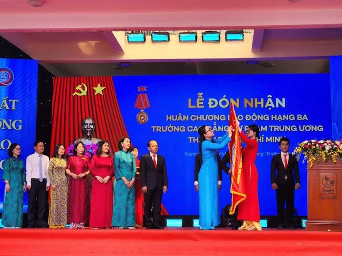 Thứ trưởng Bộ GD&ĐT Nguyễn Thị Quyên Thanh thực hiện nghi thức gắn Huân chương Lao động hạng Ba lên cờ truyền thống Trường Cao đẳng Sư phạm Trung ương TPHCM.