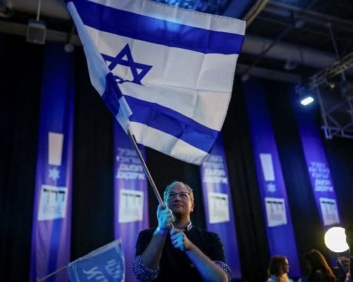 Cử tri Israel vẫy cờ ngoài phòng bỏ phiếu tại Tel Aviv. (Nguồn: The Guardian)