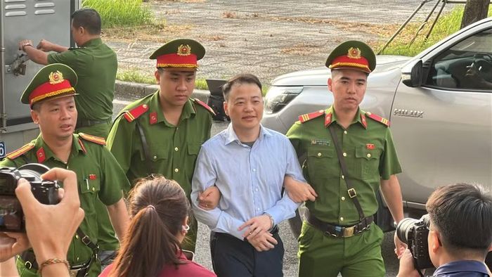 Lực lượng chức năng dẫn giải Shark Bình lên phòng xử. Ảnh: Hoàng Huy