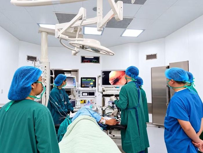 Ekip tiến hành lấy dị vật, đóng lỗ thủng cho bệnh nhân. Ảnh: Lê Đạt