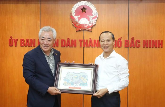 Ông Mai Sơn, Phó Chủ tịch Thường trực UBND thành phố Bắc Ninh tặng tranh dân gian Đông Hồ cho ông Kwon Sung Tae.