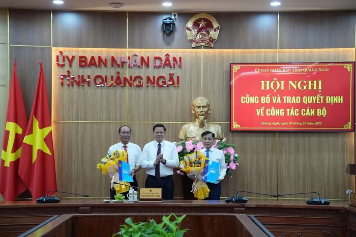 Chủ tịch UBND tỉnh Quảng Ngãi Nguyễn Đức Tâm trao quyết định và tặng hoa chúc mừng ông Nguyễn Quốc Việt (bìa trái) và ông Trần Hoài Thu (bìa phải).