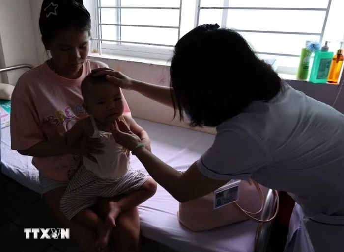 Nhân viên y tế chăm sóc, theo dõi bệnh nhi đang điều trị bệnh tay chân miệng tại khoa Y học nhiệt đới Nhi-Hồi sức tích cực và bệnh lý, Bệnh viện Phụ sản-Nhi Đà Nẵng. (Ảnh: Trần Lê Lâm/TTXVN)