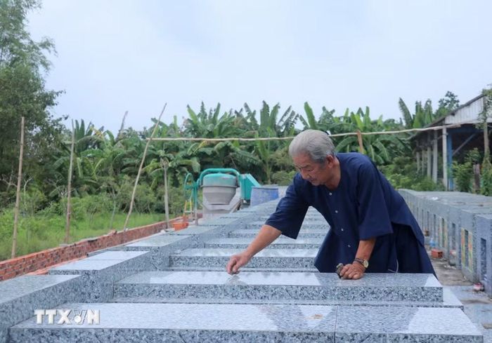 Ông Lê Quang Trưởng cũng là "lão quản trang" thầm lặng cho hơn trăm ngôi mộ tại Nghĩa trang nhân dân xã Long Kiến. (Ảnh: Công Mạo/TTXVN)