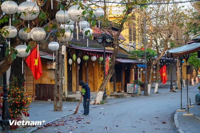 Một người dân sống ở phố cổ quét lá khô rụng lúc sáng sớm. (Ảnh: Thanh Phong/Vietnam+)