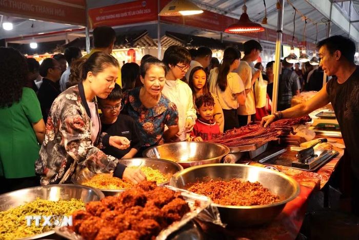 Người dân cùng du khách thưởng thức sản phẩm ẩm thực tại các gian hàng của huyện Kim Bình, tỉnh Lai Châu. (Ảnh: Quý Trung/TTXVN)