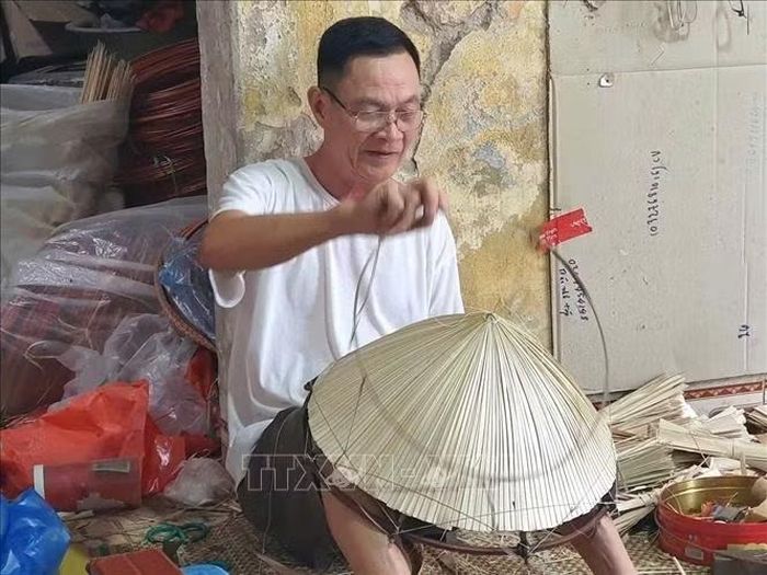 Ông Đào Văn Ngạn, 65 tuổi, người đã gắn bó hơn 50 năm với nghề làm nón ở làng Chuông, xã Thanh Oai, Hà Nội đang làm nón lá.