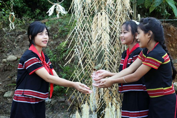 Nét đẹp hồn nhiên của các bé gái người đồng bào M'Nông ở xã Trà Leng (Đà Nẵng) bên máng nước trong bộ trang phục truyền thống.