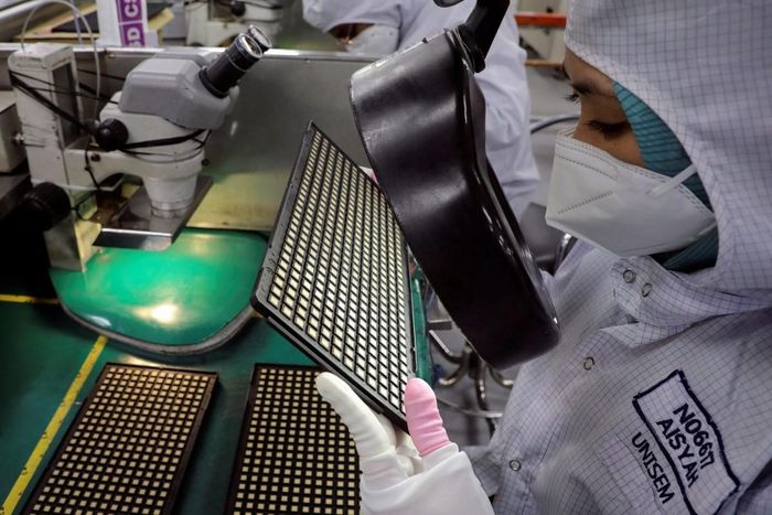 Một công nhân kiểm tra chip tại Malaysia. Ảnh: Reuters.