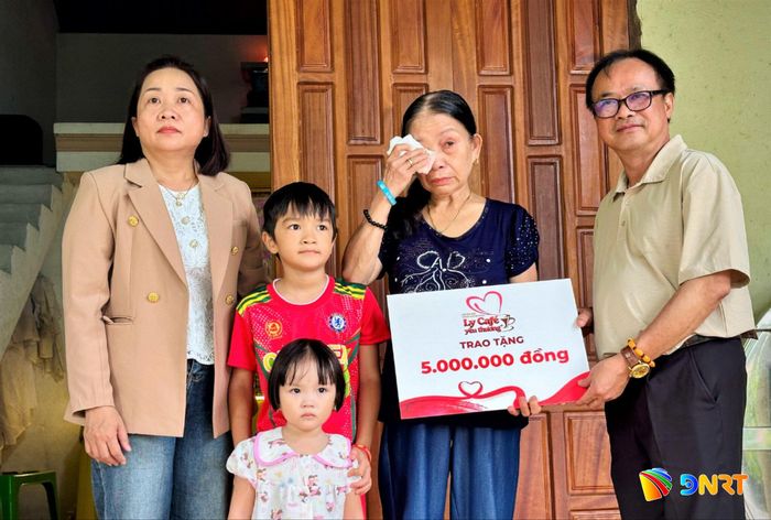 Bà Tạ Thị Kim Liên (mẹ anh Mai) xúc động khi đón nhận món quà động viên từ lãnh đạo Hội Nhà báo thành phố. Ảnh: ALĂNG NGƯỚC