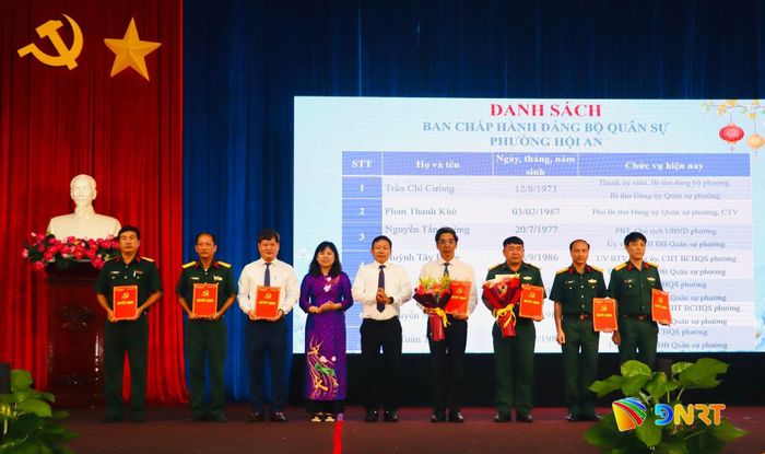 Trưởng ban Tổ chức Thành ủy Đoàn Duy Tân (thứ 5 từ trái qua) trao quyết định, tặng hoa chúc mừng Đảng bộ Quân sự phường Hội An. Ảnh: QUỐC TUẤN