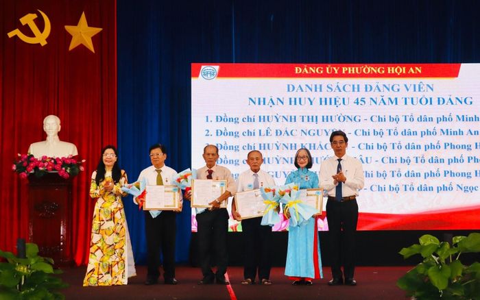 Lãnh đạo Ban Tuyên giáo Thành ủy và Đảng ủy phường Hội An trao Huy hiệu 45 năm tuổi Đảng cho các đảng viên đủ tiêu chuẩn. Ảnh: QUỐC TUẤN