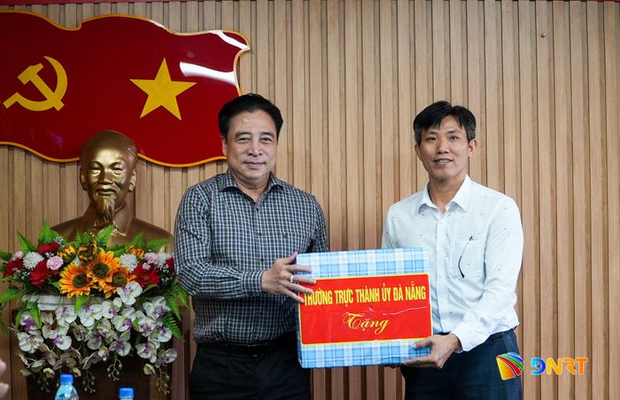 Phó Bí thư Thường trực Thành ủy Nguyễn Khắc Toàn tặng quà động viên cán bộ, nhân viên tại Trạm dược liệu Trà Linh. Ảnh: HỒ QUÂN