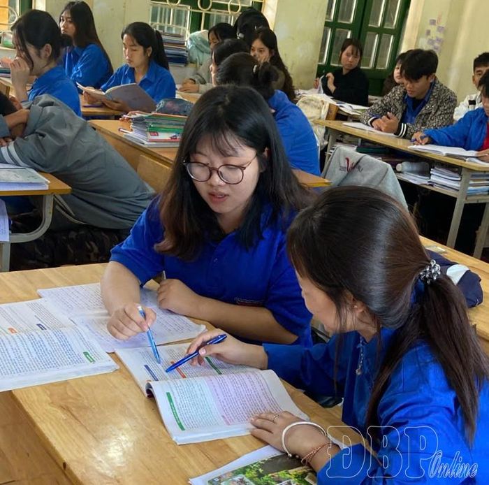 Em Lỳ Cẩm Nhung và bạn học lớp 12C3, Trường PTDTNT THPT Mường Nhé trao đổi bài tập ở lớp.