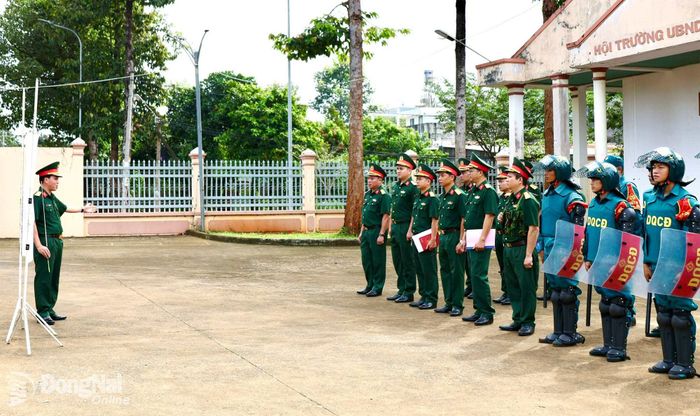 Đại tá Bùi Khánh Hòa phát lệnh báo động một trong những tình huống sẵn sàng chiến đấu đối với cán bộ, chiến sĩ Ban Chỉ huy Quân sự xã Phú Nghĩa. Ảnh: Nguyệt Hà