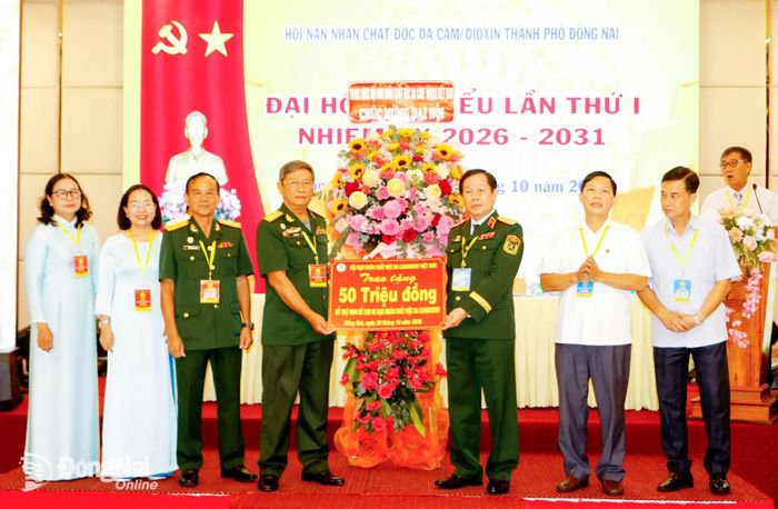 Trung tướng Nguyễn Hữu Chính, Chủ tịch Trung ương Hội Nạn nhân chất độc da cam/dioxin Việt Nam tặng hoa, quà chúc mừng đại hội. Ảnh: Văn Truyên