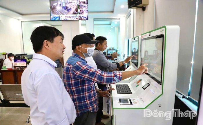Cán bộ Trung tâm Phục vụ hành chính công phường Cao Lãnh hướng dẫn người dân sử dụng kiosk tra cứu thông tin và nộp hồ sơ trực tuyến.