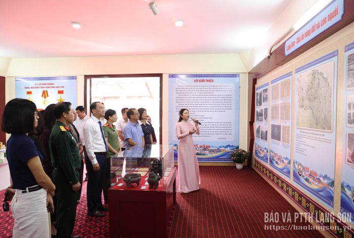 Các đại biểu tham quan, nghe thuyết minh viên giới thiệu ý nghĩa hình ảnh, tư liệu tại gian trưng bày chuyên đề
