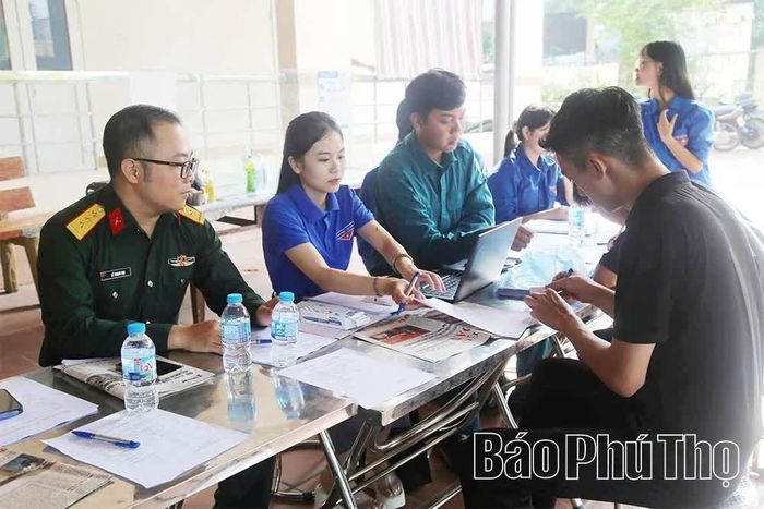 Thanh niên tình nguyện phường Việt Trì hỗ trợ công dân làm thủ tục đăng ký khám sơ tuyển sức khỏe.