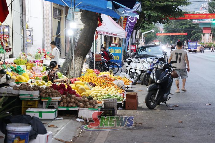 Người bày bán hoa quả lấn chiếm vỉa hè và lòng đường.