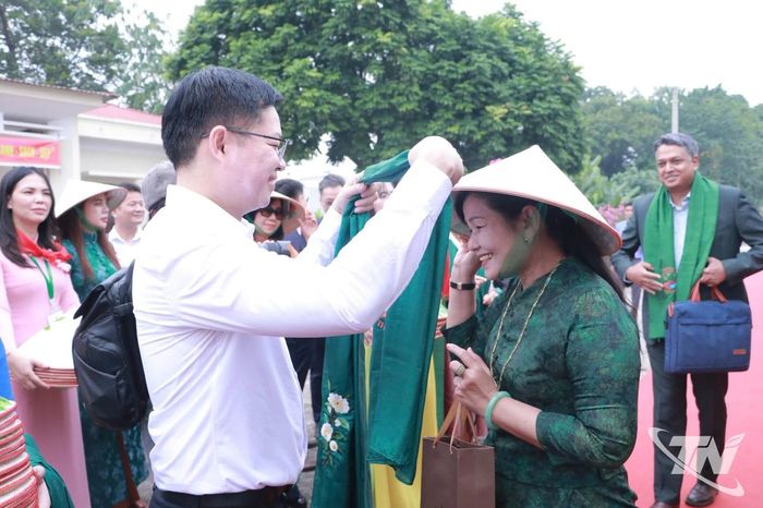 Đồng chí Đinh Quang Tuyên, Phó Bí thư Tỉnh ủy, Chủ tịch Ủy ban MTTQ tỉnh tặng khăn cho du khách.