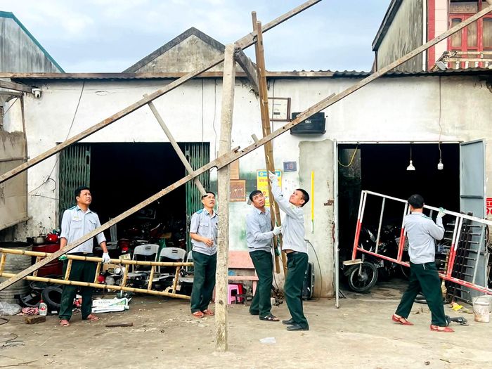 Lực lượng chức năng tháo dỡ mái che vi phạm hành lang an toàn giao thông.