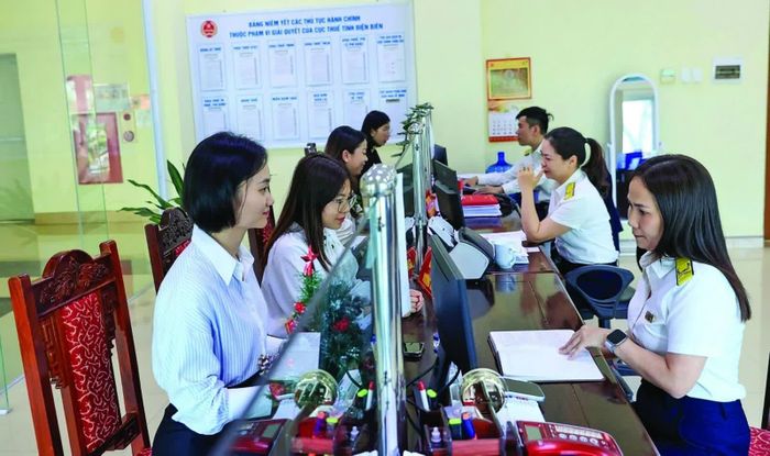 Công chức Thuế tỉnh Điện Biên hỗ trợ người nộp thuế thực hiện thủ tục. Ảnh: Đức Thanh