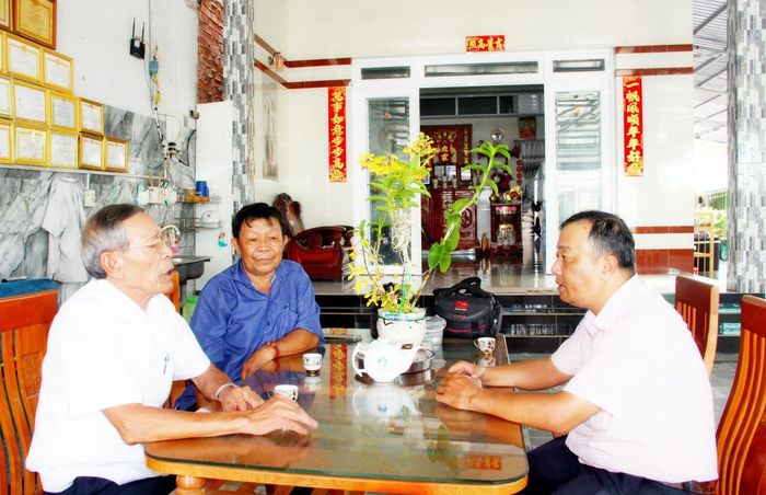 Ông Nguyễn Thanh Hóa (bên trái), Tổ trưởng Tổ tiết kiệm và vay vốn khu phố An Bình 5- người đã gắn bó với công tác này trên 10 năm