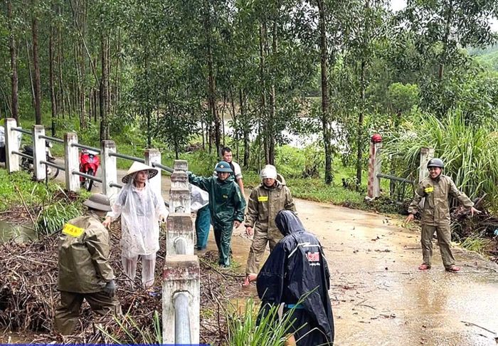 Các thành viên trong Tổ ANTT cơ sở tại xã Hưng Lộc thu dọn bùn đất, vệ sinh môi trường.