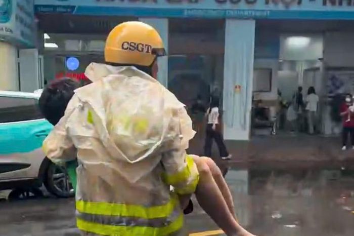 Trung tá Tạ Quang Hùng bế nam sinh vào khu vực cấp cứu.