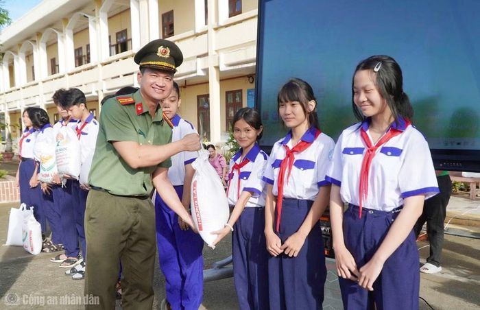 Cán bộ phòng An ninh mạng tặng quà các em học sinh tại Chiến dịch “Không một mình”.
