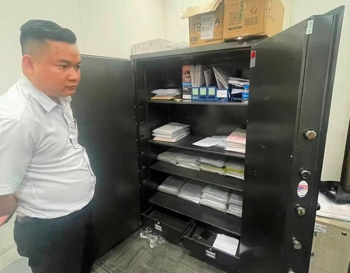 Nguyễn Hoài Phong bên két sắt chứa nhiều tài liệu liên quan.