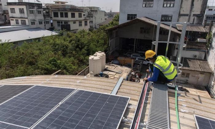 Công nhân lắp các tấm pin năng lượng mặt trời trên mái nhà dân ở tỉnh Nakhon Pathom, Thái Lan - Ảnh: PEERAPON BOONYAKIAT