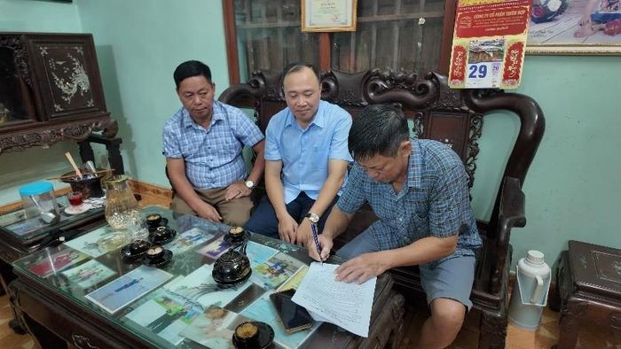 Phó Giám đốc Trung tâm Dịch vụ tổng hợp xã Dương Hòa Đỗ Xuân Đáng phối hợp với ban lãnh đạo thôn tuyên truyền trên địa bàn thôn Cát Quế 2. Ảnh: CN