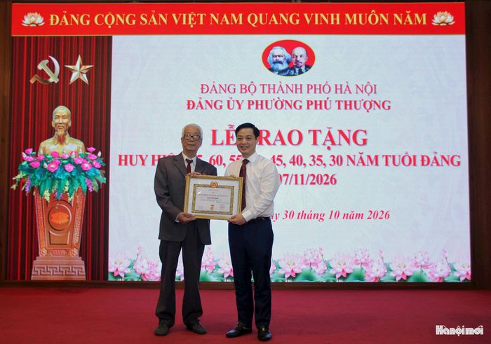 Lãnh đạo Đảng ủy phường Phú Thượng trao tặng Huy hiệu Đảng cho các đảng viên. Ảnh: Hoàng Vũ