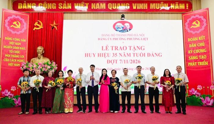 Bí thư Đảng uỷ, Chủ tịch HĐND phường Phương Liệt Nguyễn Minh Tiến và Phó Bí thư Thường trực Đảng uỷ phường Bùi Thu Trang trao Huy hiệu 35 năm tuổi Đảng cho các đảng viên. Ảnh: QH