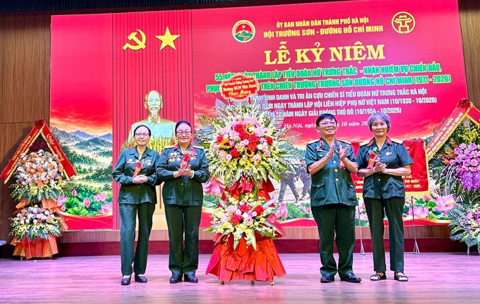 Thiếu tướng Lương Sỹ Nhung, Phó Chủ tịch Hội truyền thống Trường Sơn - Đường Hồ Chí Minh Việt Nam tặng hoa chúc mừng. Ảnh: Bảo Lâm