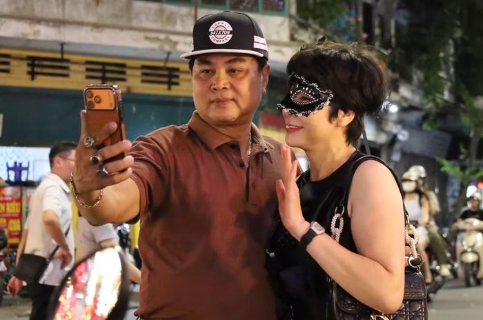 Một cặp đôi hóa trang, cùng nhau chụp ảnh lưu niệm, lưu lại khoảng khắc vui vẻ trên phố Hàng Mã