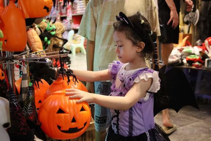 Các em nhỏ hào hứng khám phá những món đồ chơi, phụ kiện mang chủ đề Halloween được bày bán trên phố Hàng Mã