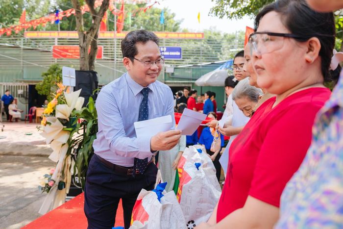 Ông Phạm Minh Tuấn, Phó Chủ tịch Ủy ban MTTQ Việt Nam TPHCM trao quà cho người dân Khu phố 28, phường Tân Hưng tại ngày hội. Ảnh: QT.