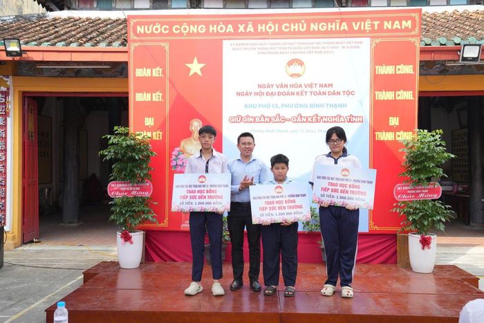 Lãnh đạo phường Bình Thạnh trao học bổng tiếp sức đến trường cho các em học sinh tại ngày hội. Ảnh: QH.