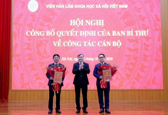 GS.TS. Lê Văn Lợi, Chủ tịch Viện Hàn lâm Khoa học xã hội Việt Nam, Phó Trưởng ban Chính sách, chiến lược Trung ương thừa ủy quyền của Ban Bí thư trao quyết định cho PGS.TS. Nguyễn Đức Minh và PGS.TS. Tạ Minh Tuấn. Ảnh: VHLKHXH