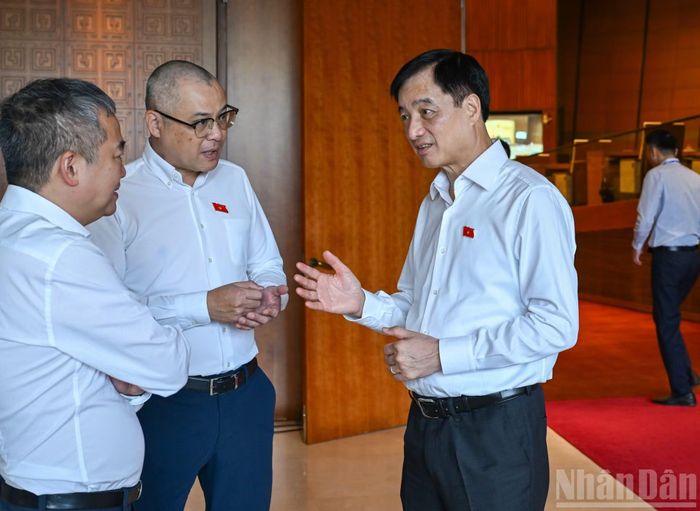 Trưởng Ban Tổ chức Trung ương Nguyễn Duy Ngọc trao đổi với các đại biểu Quốc hội bên lề phiên thảo luận. (Ảnh: DUY LINH)