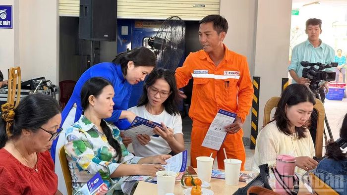 Nhân viên điện lực tư vấn người dân theo dõi điện trên App. (Ảnh: THANH HẢI)