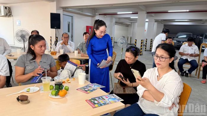 Nhân viên điện lực tư vấn người dân theo dõi điện trên App. (Ảnh: THANH HẢI)