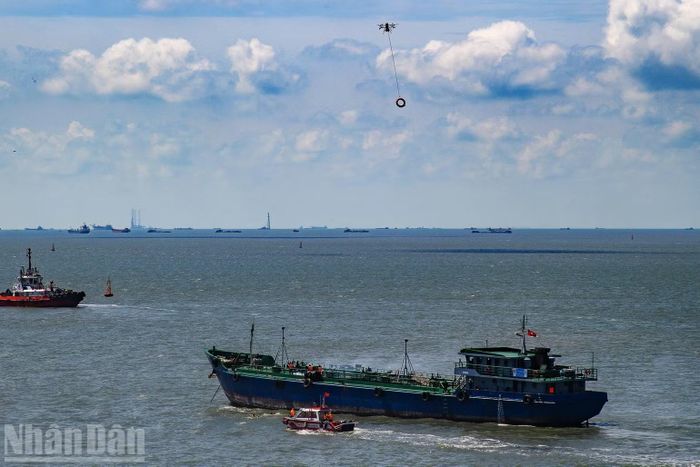 Ca-nô tiếp cận tàu gặp sự cố để cứu nạn, phía trên là drone thả áo phao.