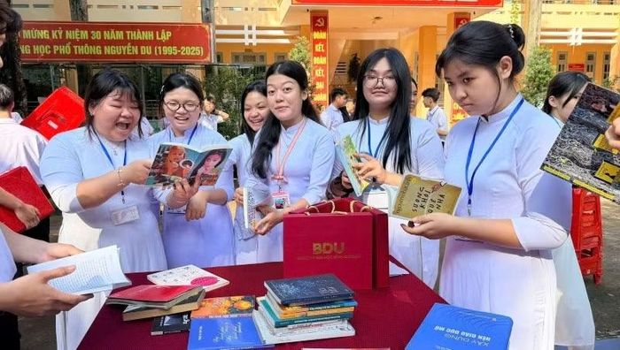 Các em học sinh Trường trung học phổ thông Nguyễn Du hào hứng khi nhận được sách từ Trung tâm Hoạt động cộng đồng và Sức khỏe. (Ảnh: CTV)