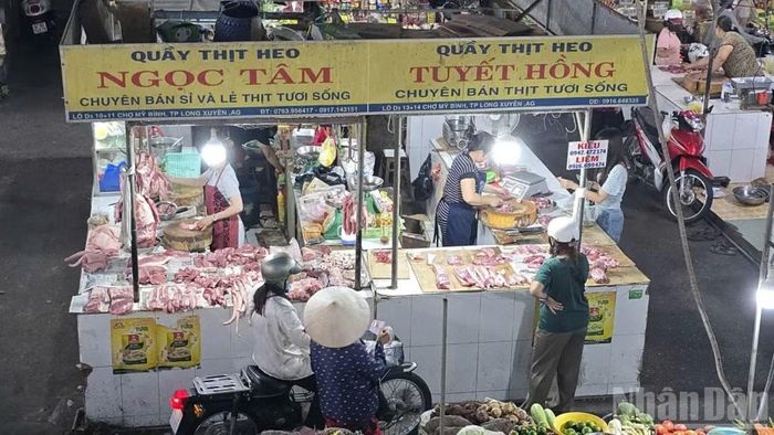 Mua bán thịt lợn tại chợ Mỹ Bình, phường Long Xuyên. (Ảnh: THANH DŨNG)