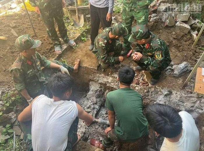  Lực lượng chức năng cất bốc hài cốt liệt sĩ trong phần đất của gia đình ông Hà Văn Sơn tại tổ dân phố Hữu Nghị. (Ảnh: LÊ LAN) 